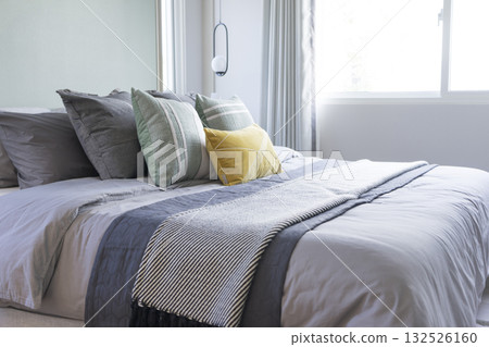 Interior view of modern bedroom with blue and yellow pillow on bed. Interior view of modern bedroom with blue and yellow pillow on bed. 132526160