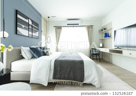 Stylish Bedroom in blue and white tone pillows setting. Cozy bedroom with art wall. Stylish Bedroom in blue and white tone pillows setting. Cozy bedroom with art wall. 132526187