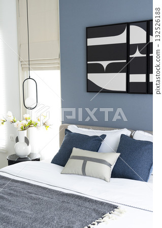 Stylish Bedroom in blue and white tone pillows setting. Cozy bedroom with art wall. Stylish Bedroom in blue and white tone pillows setting. Cozy bedroom with art wall. 132526188