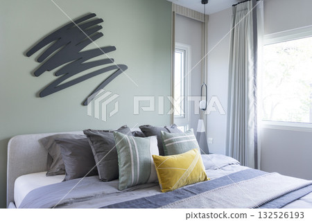 Stylish Bedroom in blue and white tone pillows setting. Cozy bedroom with art wall. Stylish Bedroom in blue and white tone pillows setting. Cozy bedroom with art wall. 132526193