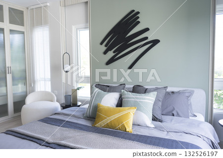 Stylish Bedroom in blue and white tone pillows setting. Cozy bedroom with art wall. Stylish Bedroom in blue and white tone pillows setting. Cozy bedroom with art wall. 132526197