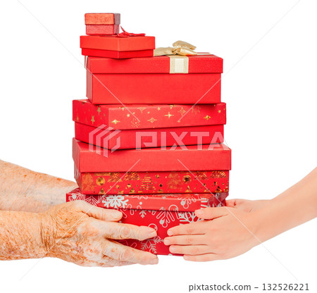 Elderly and young hands holding a stack of red gift boxes decorated for Christmas, isolated on white. Generational giving and holiday sharing concept symbolizing care, family celebration Elderly and young hands holding a stack of red gift boxes decorated for Christmas, isolated on white. Generational giving and holiday sharing concept symbolizing care, family celebration 132526221