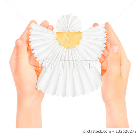Childs hands holding a white and gold paper angel ornament, symbolizing Christmas spirit, peace, protection, and handmade holiday decoration. Isolated on white background 132526272