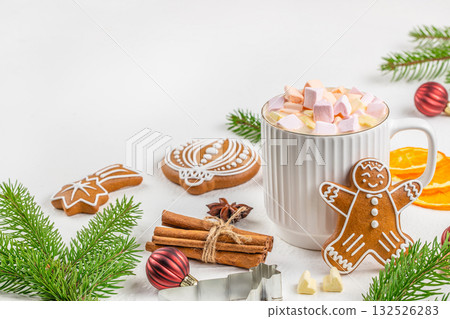 Cup of hot chocolate with marshmallows, gingerbread cookies, cinnamon sticks, and Christmas decorations on white background, cozy winter holiday scene Cup of hot chocolate with marshmallows, gingerbread cookies, cinnamon sticks, and Christmas decorations on white background, cozy winter holiday scene 132526283