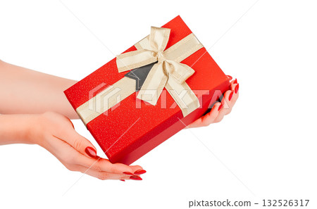 Female hands holding elegant red gift box with golden ribbon and bow, isolated on white background festive packaging concept for Christmas, New Year, Valentines Day, or celebration design 132526317