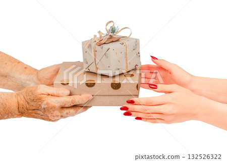 Elderly hands passing two beautifully wrapped gift boxes to young female hands concept of giving, sharing, and connection between generations, isolated on white background Elderly hands passing two beautifully wrapped gift boxes to young female hands concept of giving, sharing, and connection between generations, isolated on white background 132526322