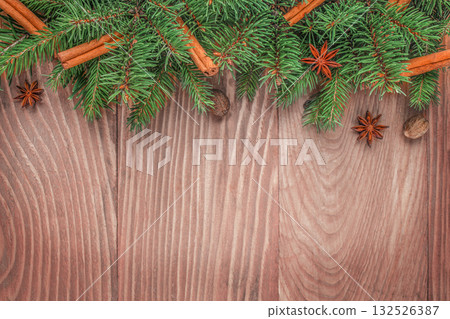 Christmas fir branches with cinnamon sticks and star anise on wooden background with copy space for festive text. top view 132526387