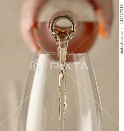closeup of white wine pouring in glass closeup of white wine pouring in glass 132527918