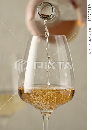 closeup of white wine pouring in glass closeup of white wine pouring in glass 132527919