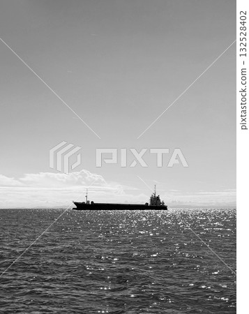 A cargo ship floating on a monochrome sea and a quiet horizon A cargo ship floating on a monochrome sea and a quiet horizon 132528402
