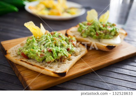 morning toast with melted cheese and guacamole 132528633