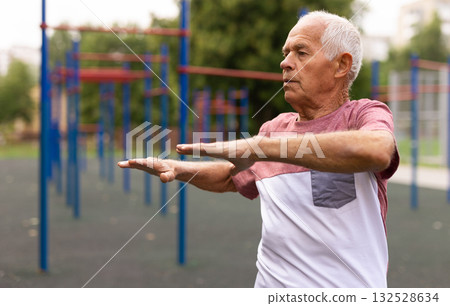 Elderly man doing gymnastic exercises in park 132528634