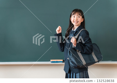 穿著西裝的小學、國中和高中女生站在黑板前揮舞著拳頭 穿著西裝的小學、國中和高中女生站在黑板前揮舞著拳頭 132528638