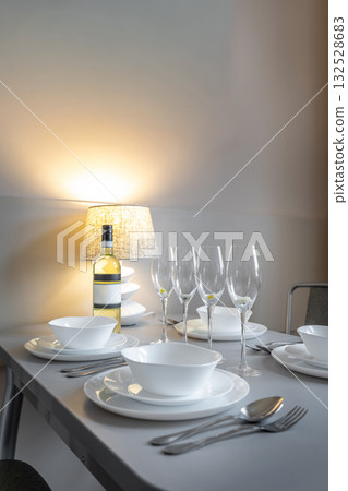 Elegant Table Setting with Wine Bottle and Warm Lamp Light Elegant Table Setting with Wine Bottle and Warm Lamp Light 132528683