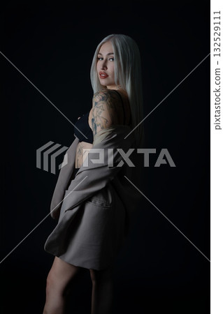 Stunning model poses elegantly in a dark studio with a stylish outfit Stunning model poses elegantly in a dark studio with a stylish outfit 132529111