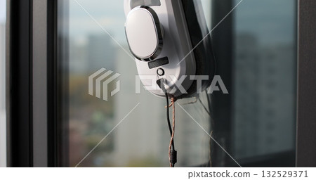 Close-up of automatic window cleaner robot. Working on residential window. Simplicity and convenience of window cleaning. Close-up of automatic window cleaner robot. Working on residential window. Simplicity and convenience of window cleaning. 132529371