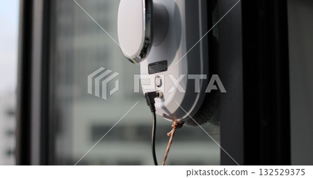 Close-up of automatic window cleaner robot. Working on residential window. Simplicity and convenience of window cleaning. Close-up of automatic window cleaner robot. Working on residential window. Simplicity and convenience of window cleaning. 132529375