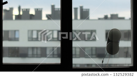 Window cleaning robot in action on glass, modern smart home appliance for automated cleaning. Simplicity and convenience of window cleaning. 132529382