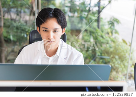 操作個人計算機的白色外套男性 132529837