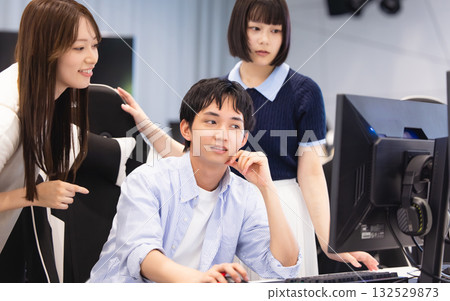 Men and women discussing while looking at a computer Men and women discussing while looking at a computer 132529873