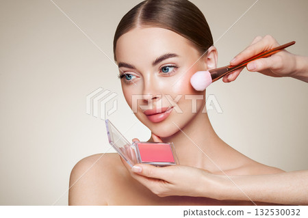 Makeup artist applies eye shadow 132530032