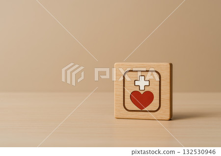 Medical service and health insurance concepts are symbolized by wooden block with red heart and white cross on neutral background conveying care and protection 132530946