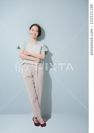 Image of a business woman with a beautiful mint green background, smiling and holding a laptop 132531199