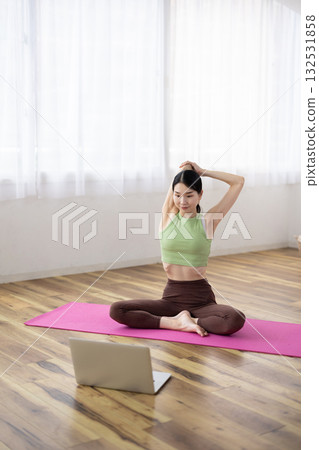 Middle-aged woman taking online yoga lessons using a laptop 132531858