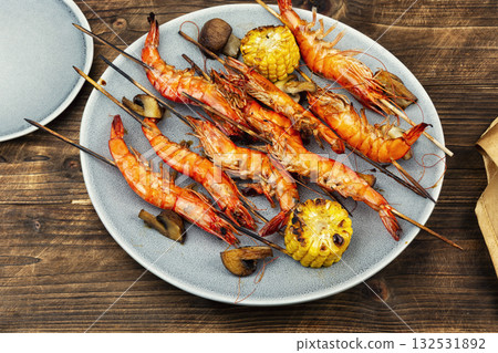 Shrimp langoustines skewers on wooden surface. Shrimp langoustines skewers on wooden surface. 132531892