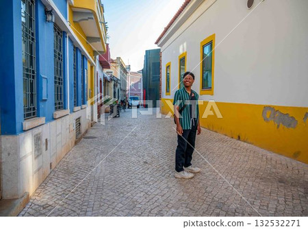 Handsome young African american tourist on ancient European cobblestone street Portugal 132532271