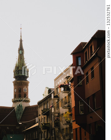 Dominating Krakow skyline, tower of St. Florians Gate rises above charming residential buildings of old town, embodying Polish architectural history. Polish urban landscape. Krakow historic district Dominating Krakow skyline, tower of St. Florians Gate rises above charming residential buildings of old town, embodying Polish architectural history. Polish urban landscape. Krakow historic district 132532761