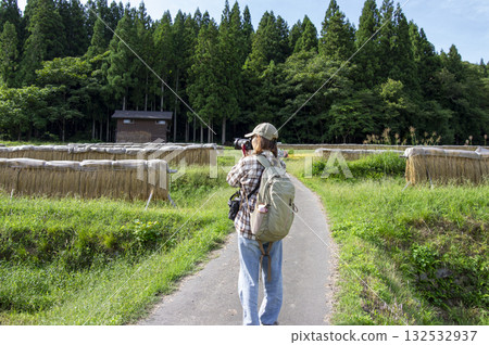 一位女旅行者背對著鏡頭，正在拍攝白川鄉的鄉村景色。 132532937