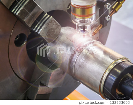 Welding process of a metallic pipe with precise laser application in a workshop setting Welding process of a metallic pipe with precise laser application in a workshop setting 132533693