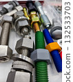 Various bolts and nuts arranged neatly on a work surface showcasing different colors and materials 132533703