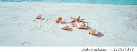 Starfish and seashells scattered across pristine white sand evoke tranquility, while turquoise water gently laps in the background, creating an idyllic summer scene Starfish and seashells scattered across pristine white sand evoke tranquility, while turquoise water gently laps in the background, creating an idyllic summer scene 132534377