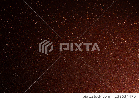 Red brown glitter background with bright lower left spot and sparkling grains spreading outward Red brown glitter background with bright lower left spot and sparkling grains spreading outward 132534479
