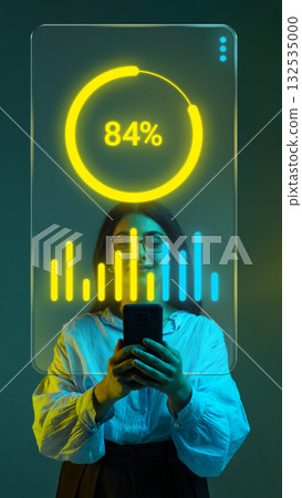 Trendy collage. Woman viewing digital data analytics dashboard on smartphone with glowing hologram Trendy collage. Woman viewing digital data analytics dashboard on smartphone with glowing hologram 132535000