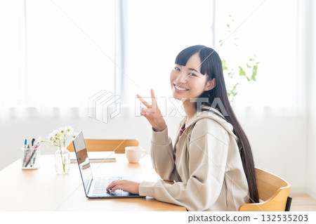 A female college student operating a computer at home A female college student operating a computer at home 132535203