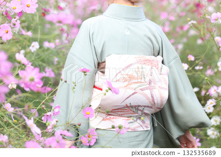 A woman in a kimono walking through a cosmos field A woman in a kimono walking through a cosmos field 132535689
