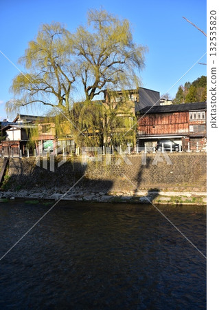 Takayama City, Gifu Prefecture, Japan - During the Takayama Spring Festival, the streets around Nakabashi Bridge, a popular tourist spot, with beautiful blue skies, old houses, and willow trees Takayama City, Gifu Prefecture, Japan - During the Takayama Spring Festival, the streets around Nakabashi Bridge, a popular tourist spot, with beautiful blue skies, old houses, and willow trees 132535820