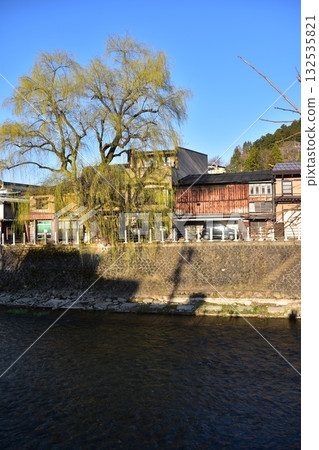Takayama City, Gifu Prefecture, Japan - During the Takayama Spring Festival, the streets around Nakabashi Bridge, a popular tourist spot, with beautiful blue skies, old houses, and willow trees Takayama City, Gifu Prefecture, Japan - During the Takayama Spring Festival, the streets around Nakabashi Bridge, a popular tourist spot, with beautiful blue skies, old houses, and willow trees 132535821