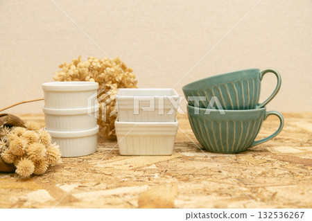 A table photo of Western-style tableware: cocottes and soup cups lined up on plywood 132536267