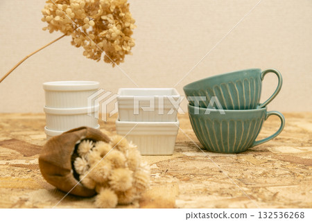 A table photo of Western-style tableware: cocottes and soup cups lined up on plywood 132536268