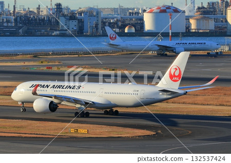 Passenger plane taxiing in the morning sun 132537424