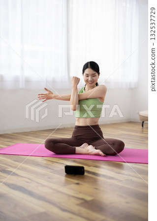中年婦女一邊伸懶腰一邊看著她的智慧型手機 132537729