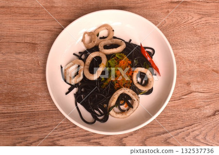 spicy fried black squid ink spaghetti with slice cuttlefish dressing shrimp egg and basil on plate spicy fried black squid ink spaghetti with slice cuttlefish dressing shrimp egg and basil on plate 132537736