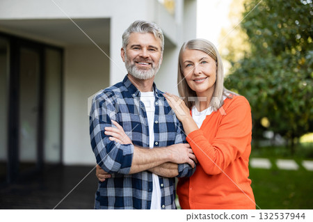 Senior man and woman together near their house looking happy and contented 132537944