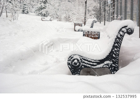 Winter Wonderland with Snow Covered Benches in City Park. Cold winter weather. Outdoors. Winter Wonderland with Snow Covered Benches in City Park. Cold winter weather. Outdoors. 132537995
