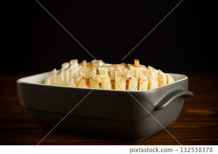 Sliced potatoes in a baking dish Sliced potatoes in a baking dish 132538378