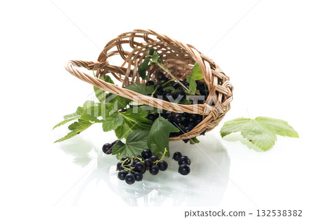 Ripe blackcurrants in a basket on a white background Ripe blackcurrants in a basket on a white background 132538382